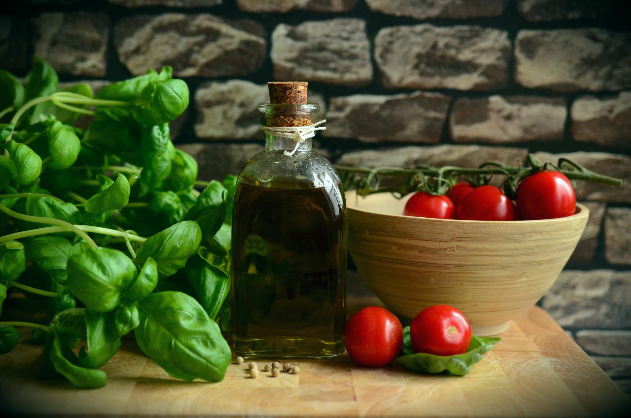 tomatoes, olive oil and basil on a board